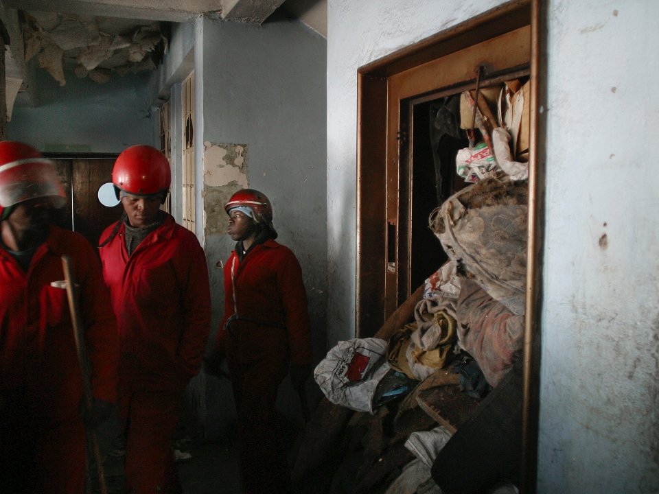 Members of Wozani Security, known as the Red Ants, enter the Chelsea Hotel in Hillbrow during a clean-up operation